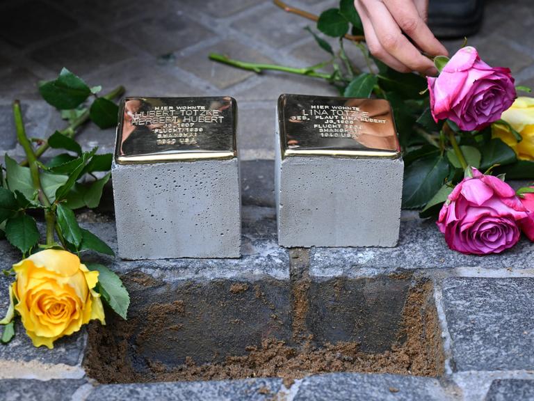 Zwei neue Stolpersteine werden in Kopfsteinpflaster verlegt. Zwei neue Stolpersteine werden in Kopfsteinpflaster verlegt.