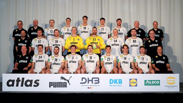 Die Deutsche Handball-Nationalmannschaft sitzt und steht zu einem Gruppenfoto zusammen