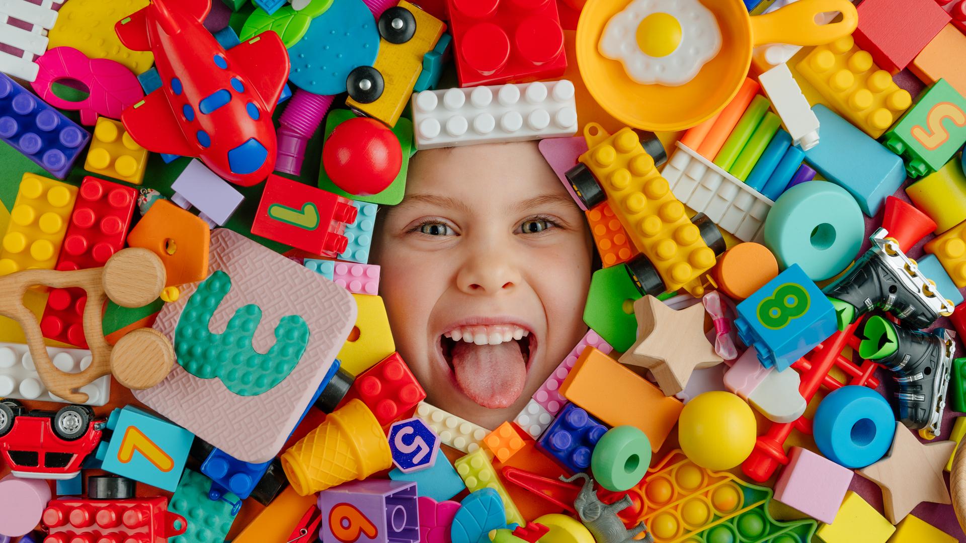 Gesicht eines lachenden Kindes - von Lego- und anderen Bausteinen umgeben Gesicht eines lachenden Kindes - von Lego- und anderen Bausteinen umgeben