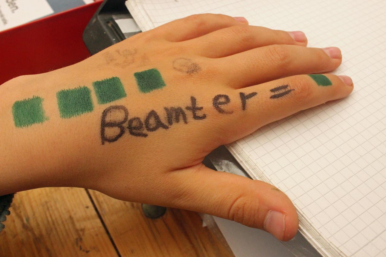 Kinderhand, auf der "Beamter" geschrieben steht