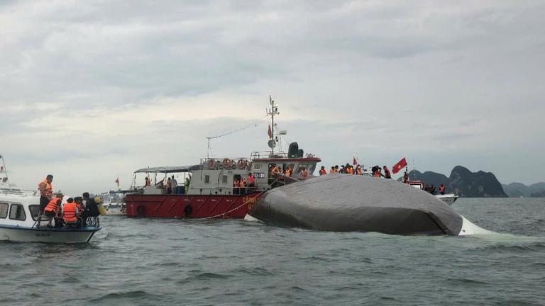 Das Boot schwimmt kopfüber im Wasser. Dahinter und daneben jeweils ein Boot mit Rettungskräften. Das Boot schwimmt kopfüber im Wasser. Dahinter und daneben jeweils ein Boot mit Rettungskräften.