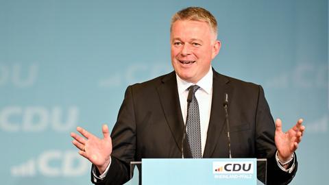 Der Vorsitzende der rheinland-pfälzischen CDU, Gordon Schnieder, steht an einem Pult, spricht und hat die Arme ausgebreitet.