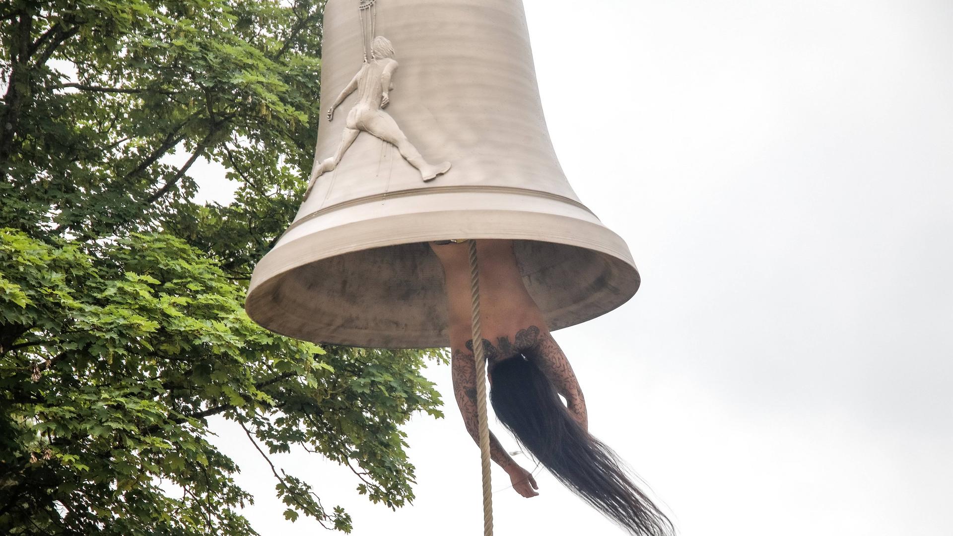 Die österreichische Künstlerin und Performerin Florentina Holzinger hängt kopfüber ohne Kleidung in einer Glocke und fungiert selbst als "Klöppel" - bei der Biennale in Venedig 