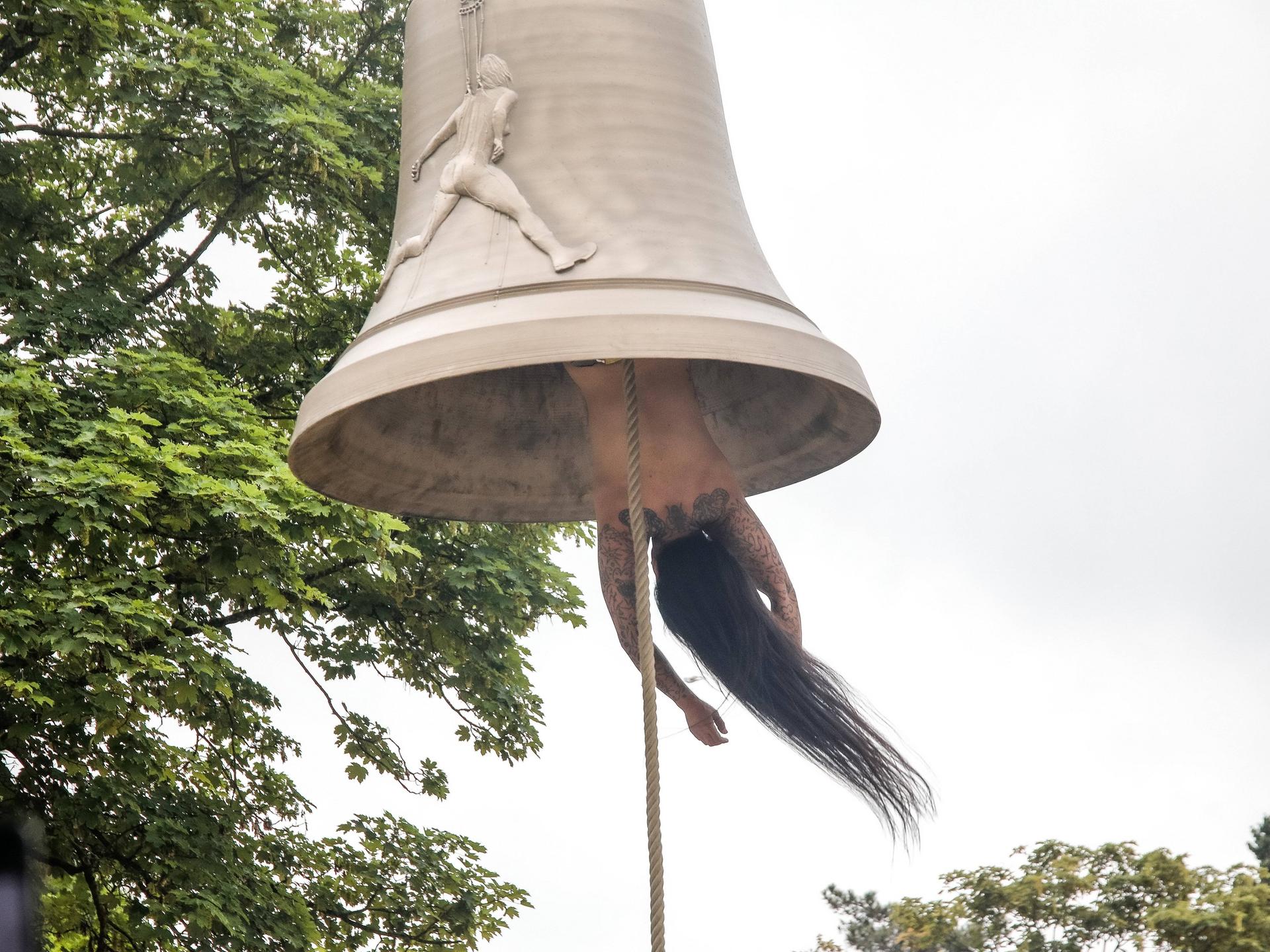 Die österreichische Künstlerin und Performerin Florentina Holzinger hängt kopfüber ohne Kleidung in einer Glocke und fungiert selbst als "Klöppel" - bei der Biennale in Venedig 