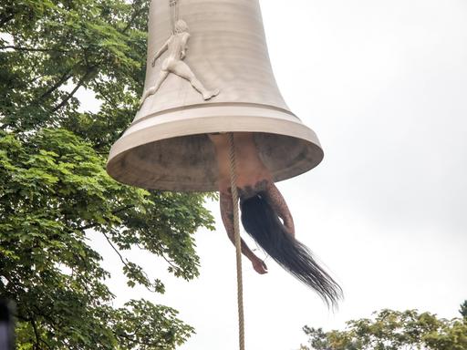 Die österreichische Künstlerin und Performerin Florentina Holzinger hängt kopfüber ohne Kleidung in einer Glocke und fungiert selbst als "Klöppel" - bei der Biennale in Venedig 