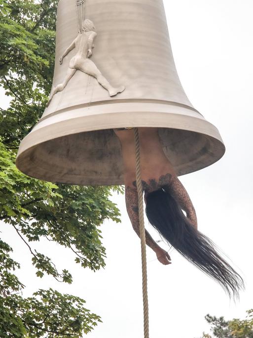 Die österreichische Künstlerin und Performerin Florentina Holzinger hängt kopfüber ohne Kleidung in einer Glocke und fungiert selbst als "Klöppel" - bei der Biennale in Venedig 