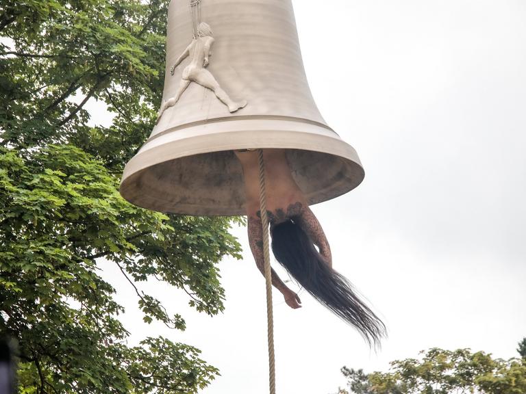 Die österreichische Künstlerin und Performerin Florentina Holzinger hängt kopfüber ohne Kleidung in einer Glocke und fungiert selbst als "Klöppel" - bei der Biennale in Venedig 