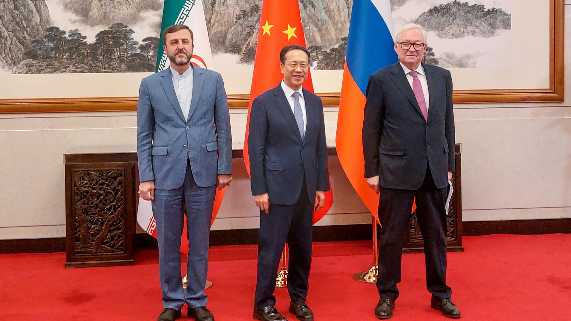 Der iranische Außenminister Gharibabadi und seine Amtskollegen aus China und Russland, Zhaoxu und Ryabkov stehen für ein Foto nebeneinander. Hinter ihnen die jeweiligen Landesfahnen. Der iranische Außenminister Gharibabadi und seine Amtskollegen aus China und Russland, Zhaoxu und Ryabkov stehen für ein Foto nebeneinander. Hinter ihnen die jeweiligen Landesfahnen.