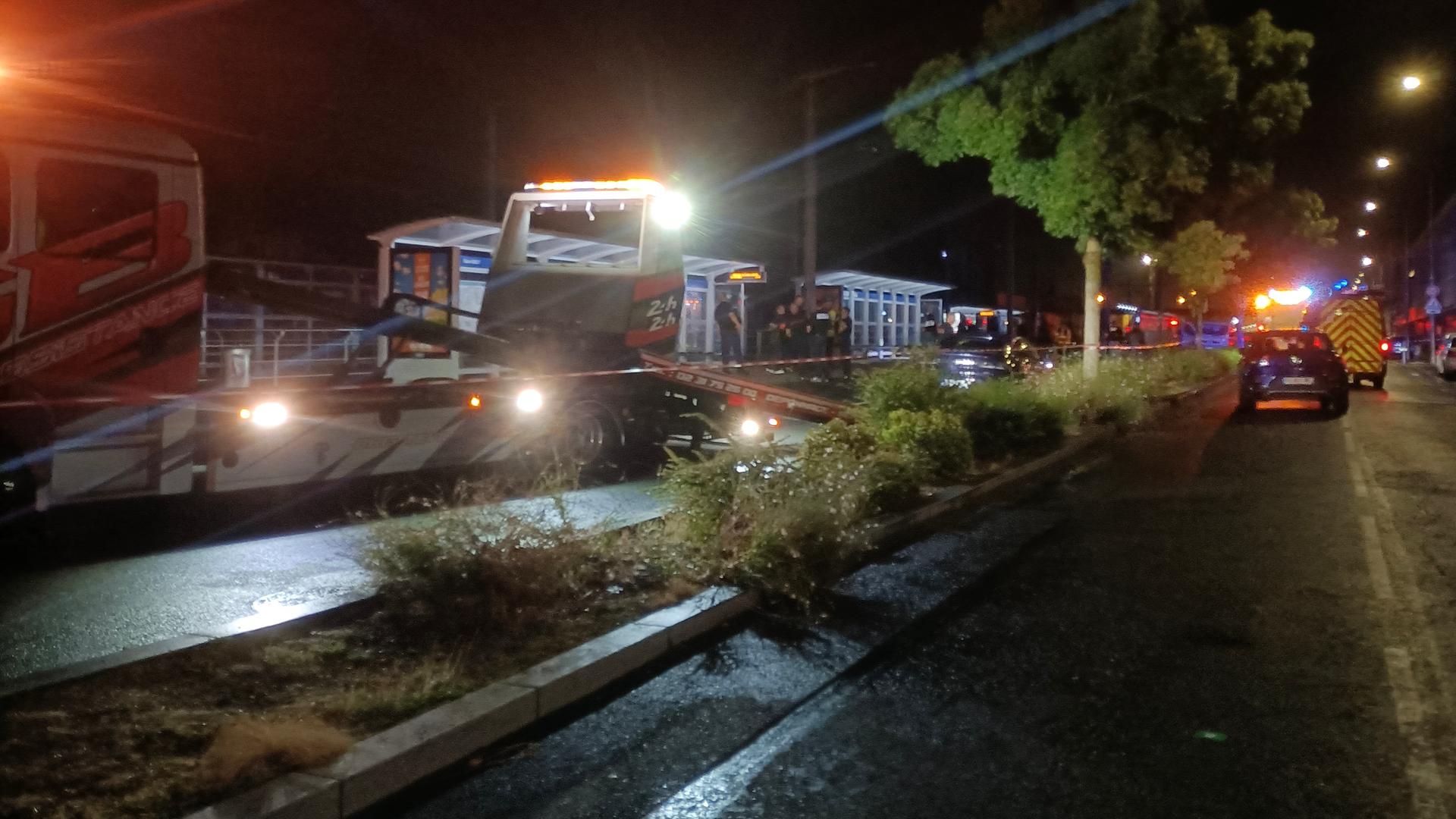 Zu sehen sind Einsatzfahrzeuge von Polizei und Rettungskräften sowie Absperrungen bei Nacht.