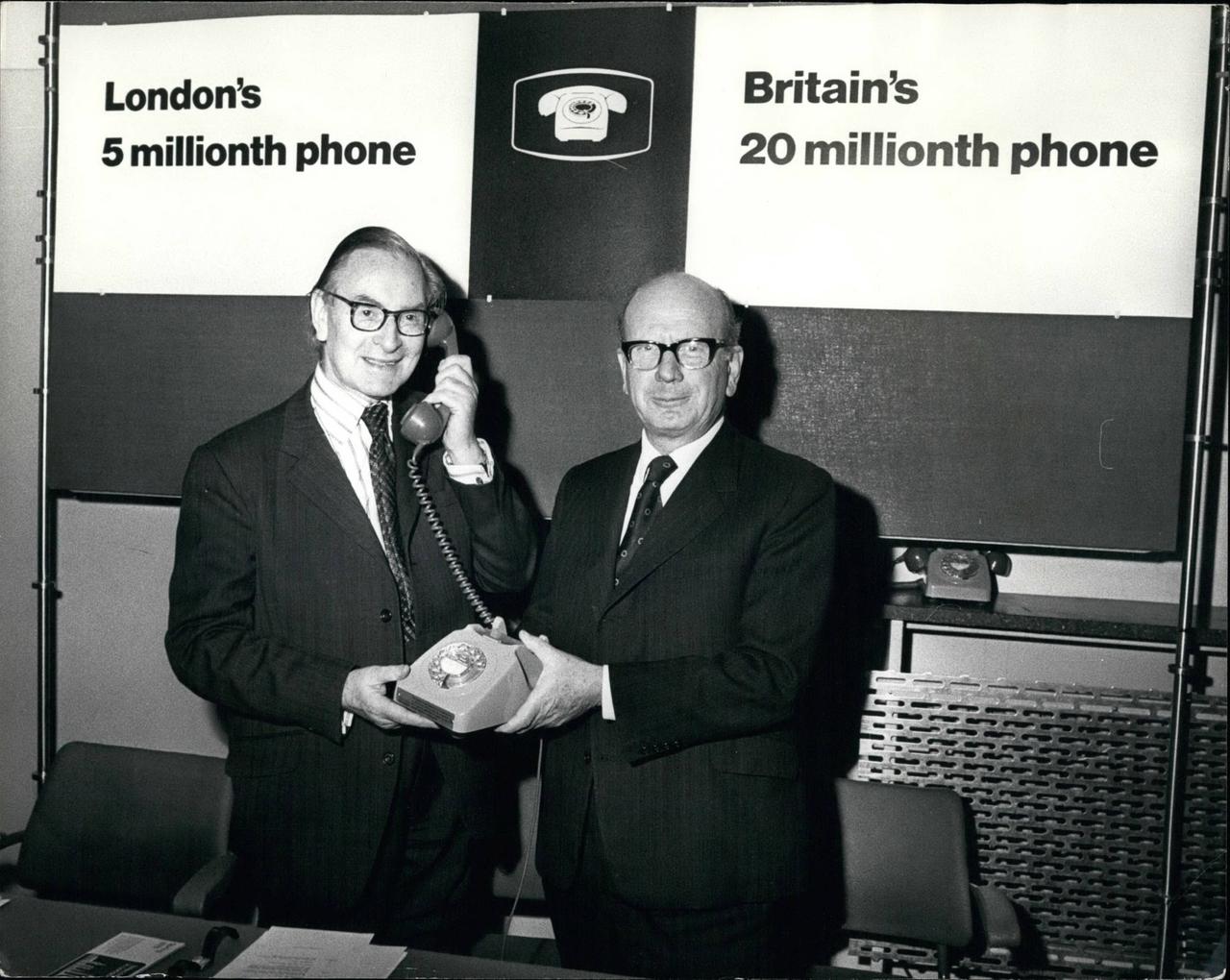 Zwei Männer halten ein altes Kabeltelefon in den Händen