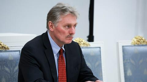Kreml-Sprecher Dmitri Peskow sitzt im Kreml und schaut ernst. 