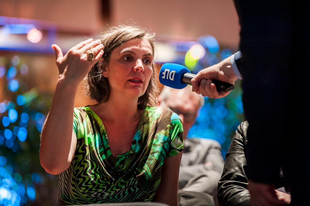 Eine Frau stellt eine Frage in ein Mikrofon