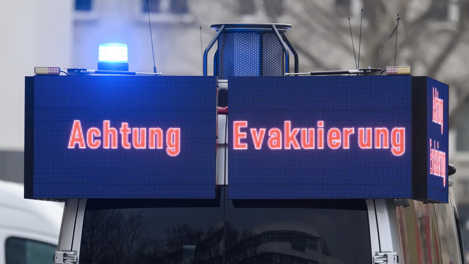 Ein Polizeiwagen fährt während einer Evakuierung der Innenstadt durch die Straßen, um Bürger zu informieren. Auf Bildschirmen am Wargen steht "Achtung Evakuierung". Ein Polizeiwagen fährt während einer Evakuierung der Innenstadt durch die Straßen, um Bürger zu informieren. Auf Bildschirmen am Wargen steht "Achtung Evakuierung".
