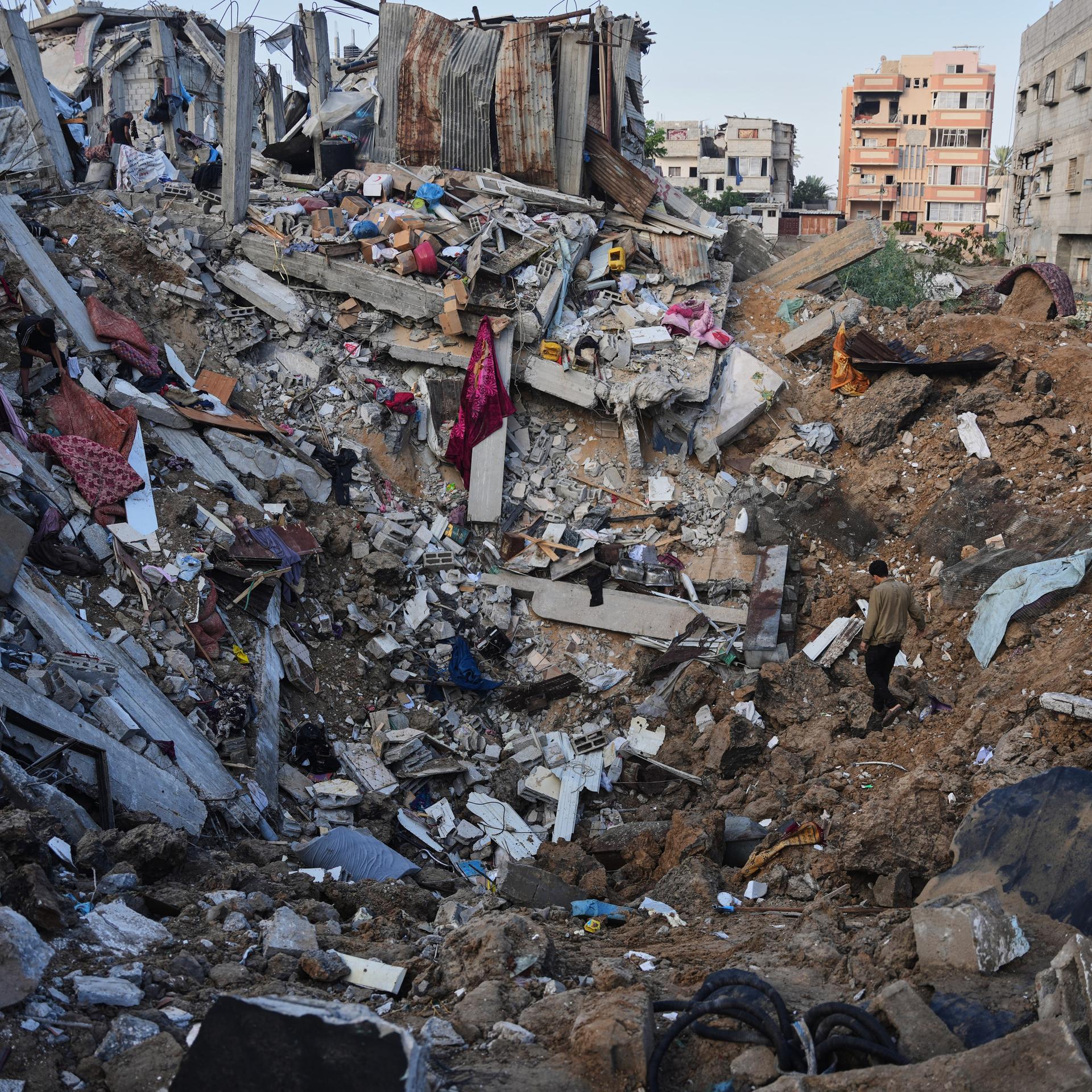 Palästinensische Gebiete, al-Bureij: Palästinenser begutachten im Flüchtlingslager in der Mitte des Gazastreifens zerstörte Gebäude nach einem israelischen Luftangriff. 