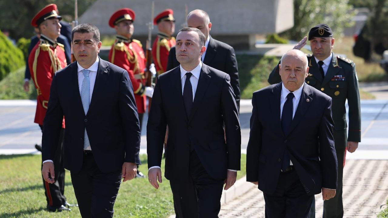 Georgien, Tiflis: Der georgische Regierungschef Garibaschwili geht zwischen zwei Personen. Hinter ihnen stehen Soldaten Spalier. Georgien, Tiflis: Der georgische Regierungschef Garibaschwili geht zwischen zwei Personen. Hinter ihnen stehen Soldaten Spalier.