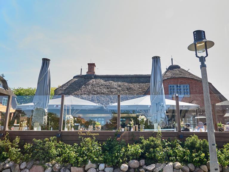 Blick auf das Lokal "Pony" in Kampen auf Sylt mit davorliegender Terrasse. 