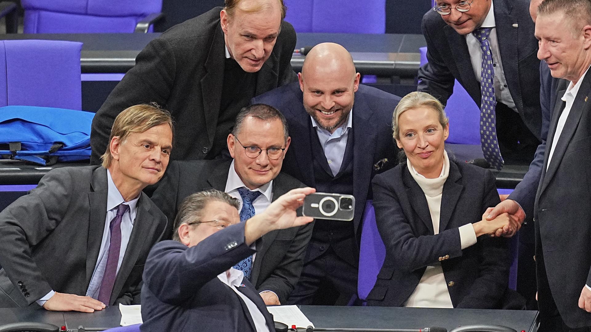 Abgeordnete der AfD-Bundestagsfraktion freuen sich nach der Bekanntgabe des Ergebnisses der namentlichen Abstimmung über Anträge der Unionsfraktion zur Verschärfung der Migrationspolitik und machen ein Selfie.