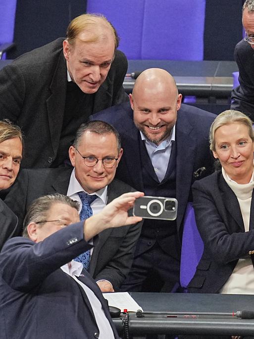 Abgeordnete der AfD-Bundestagsfraktion freuen sich nach der Bekanntgabe des Ergebnisses der namentlichen Abstimmung über Anträge der Unionsfraktion zur Verschärfung der Migrationspolitik und machen ein Selfie.