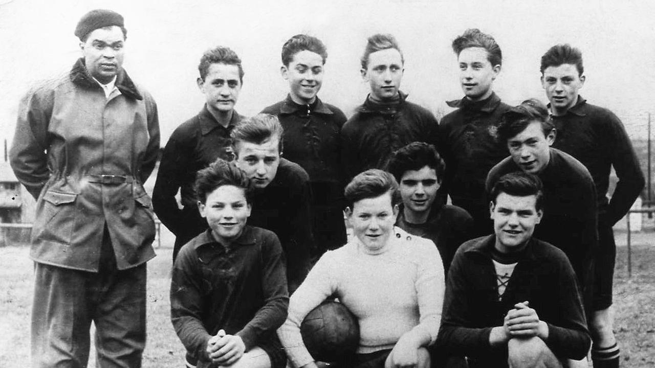 Ein Schwarz-Weiß-Foto zeigt den Fußball-Trainer Heinz Kerz (ganz links) in den Fünfzigerjahren auf einem Mannschaftsfoto mit jugendlichen Fußballern.
