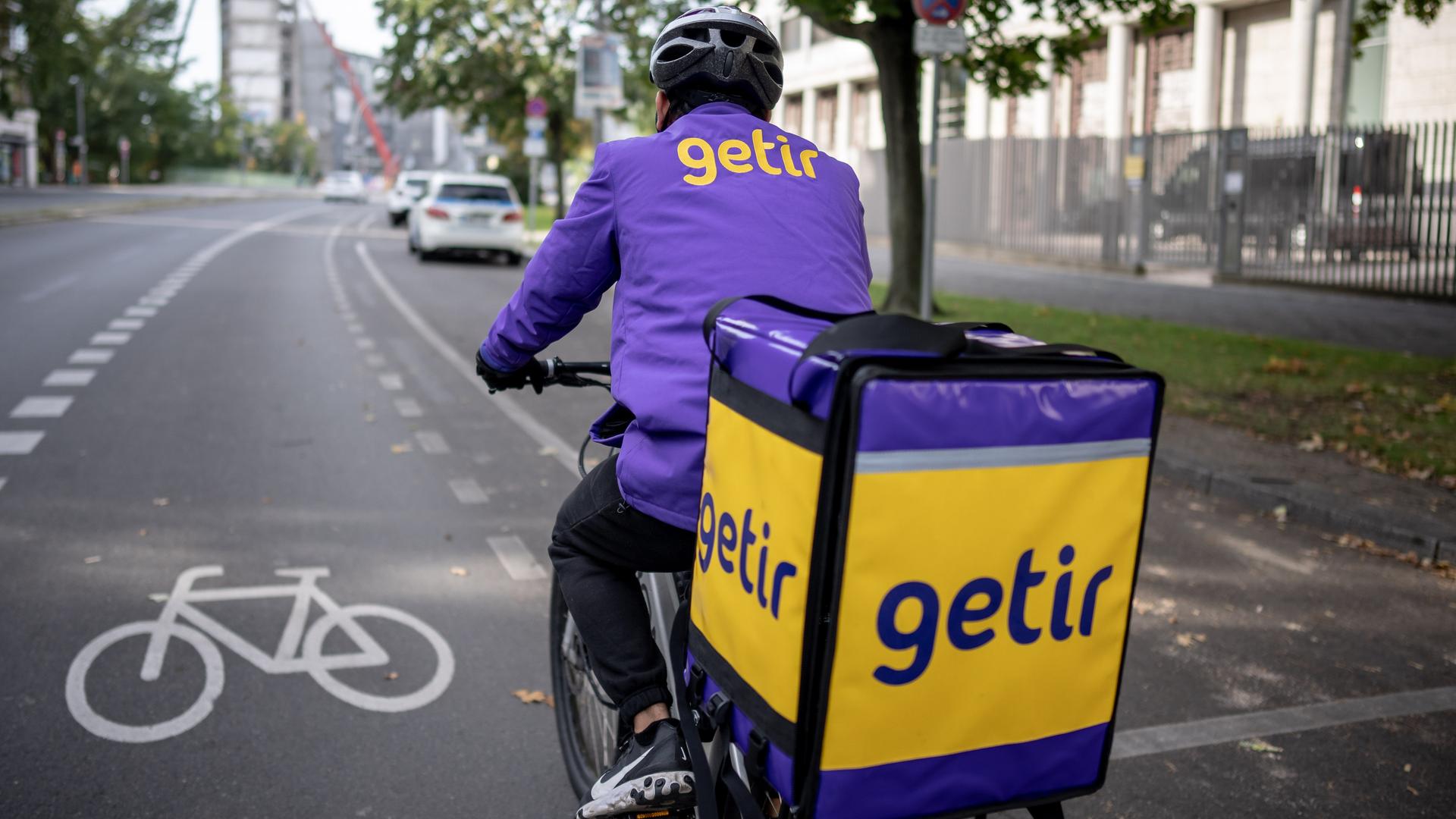 Ein Lieferfahrer des türkischen Lieferdienstes "Getir" fährt mit seinem Fahrrad durch Berlin. Ein Lieferfahrer des türkischen Lieferdienstes "Getir" fährt mit seinem Fahrrad durch Berlin.