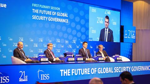 Jordaniens Außenminister Safadi, Bundesaußenminister Wadephul und die britische Außenministerin Cooper sitzen bei einer Sicherheitskonferenz an einem Tisch. Im Hingergrund ein blaues Plakat mit der Aufschrift "The Future of Global Security Governance".