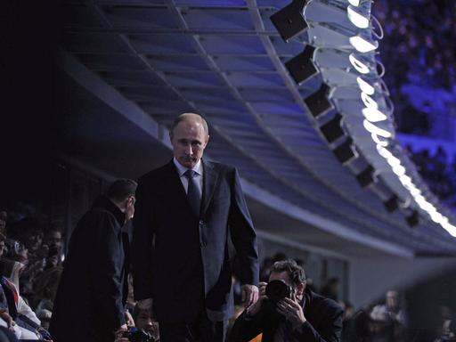 Russlands Präsident Wladimir Putin läuft bei der Schlusszeremonie zu den Olympischen Winterspielen in Sotschi auf der Zuschauertribüne entlang. 