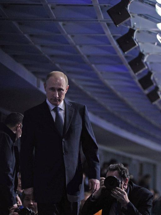 Russlands Präsident Wladimir Putin läuft bei der Schlusszeremonie zu den Olympischen Winterspielen in Sotschi auf der Zuschauertribüne entlang. 