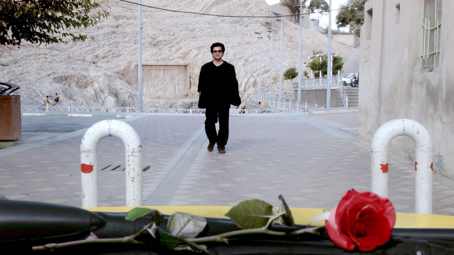 In seinem heimlich gefilmten Werk "Taxi" sieht man Regisseur Jafar Panahi durch die Scheibe eines Autos, wie er eine Straße entlang geht.
