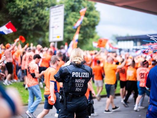 Eine Polizisten beobachtet den Fanwalk in Dortmund der niederländischen Fans bei der Fußball-Europameisterschaft 2024.