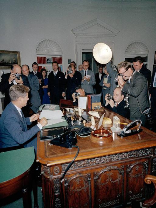 Präsident John F. Kennedy während der Kuba-Krise, umringt von Reportern im Weißen Haus.