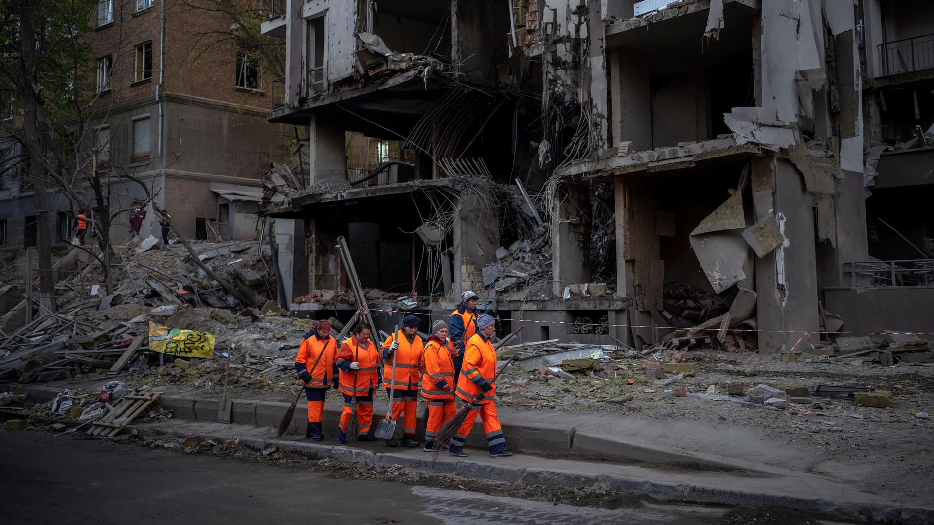 Arbeiter eines Aufräumtrupps in Kiew vor einem Gebäude nach einer Explosion.