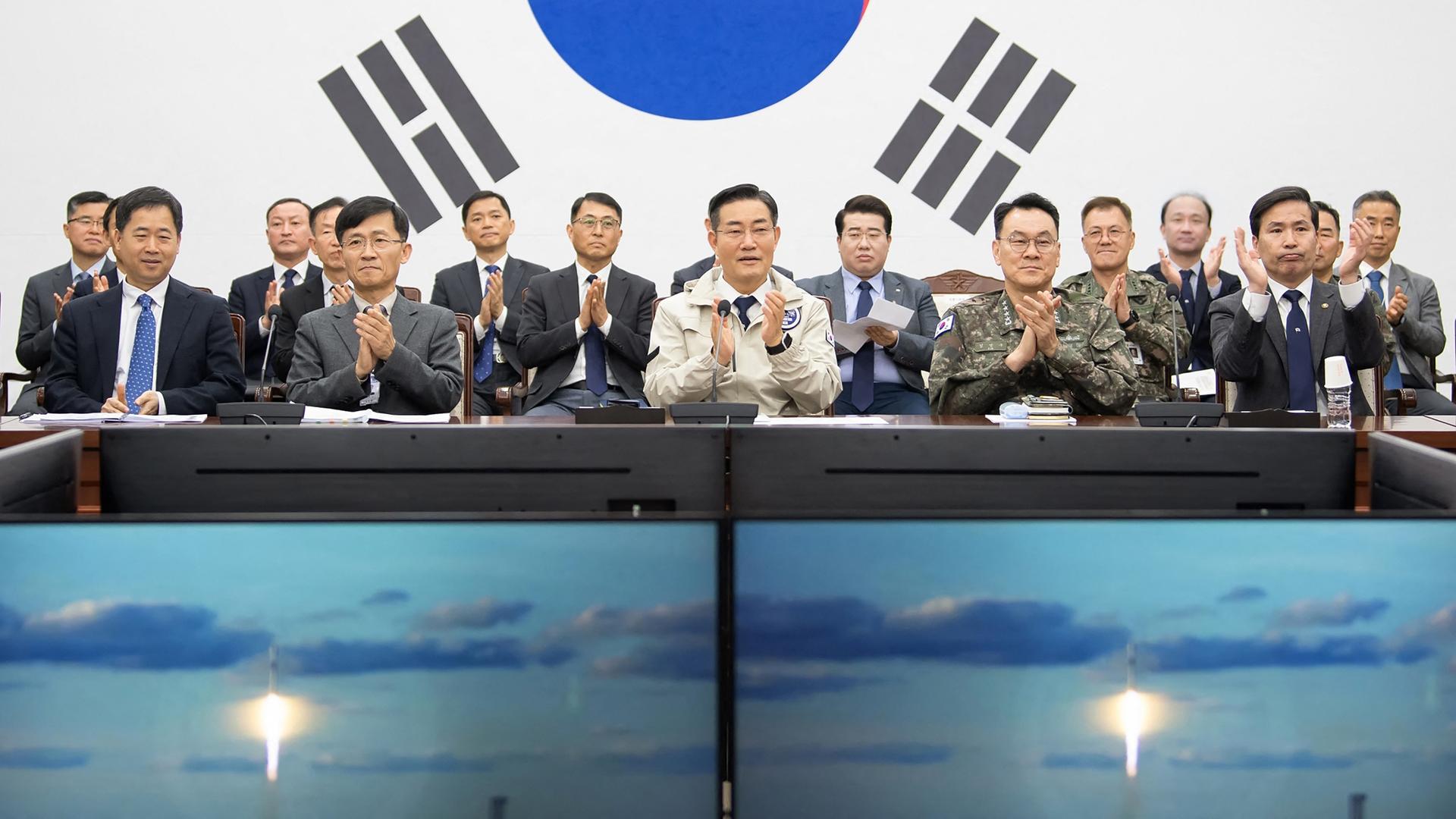 Der südkoreanische Verteidigungsminister Shin Won-sik und Mitarbeiter beobachten den Start des Satelliten in einer Live-Übertragung.