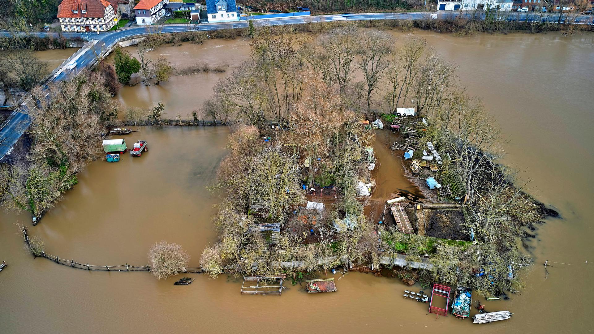 Das Bild zeigt ein Hochwasser-Gebiet in Niedersachsen. Bäume, Gebäude und Autos sind von Wasser umspült. 