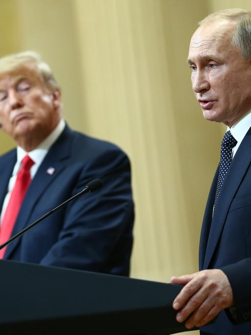 Russlands Präsident Vladimir Putin und US-Präsident Donald Trump stehen auf einem Podium in Helsinki im Jahr 2018