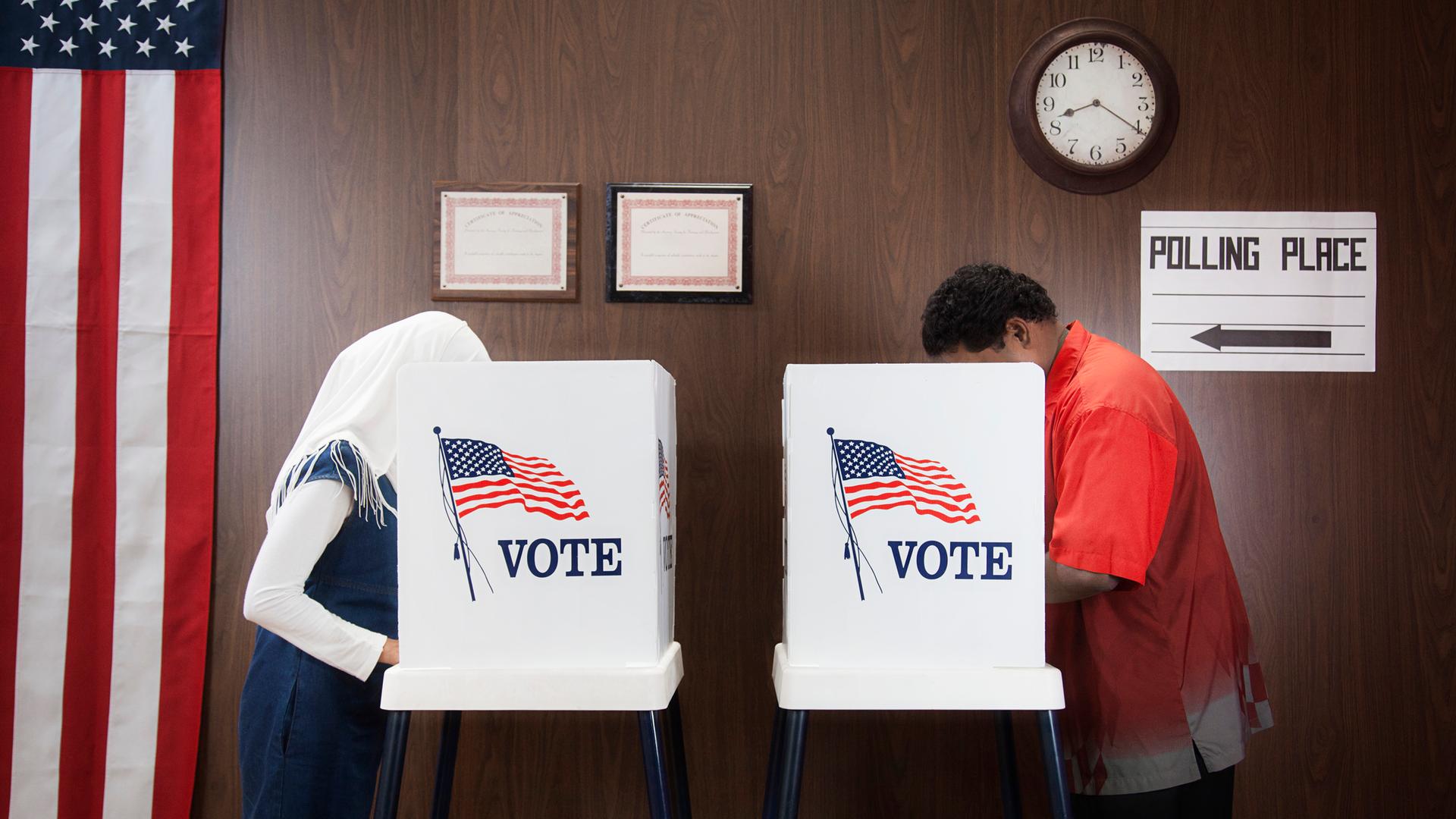 USA: Wählerinnen und Wähler hinter einem "Vote" Stand.