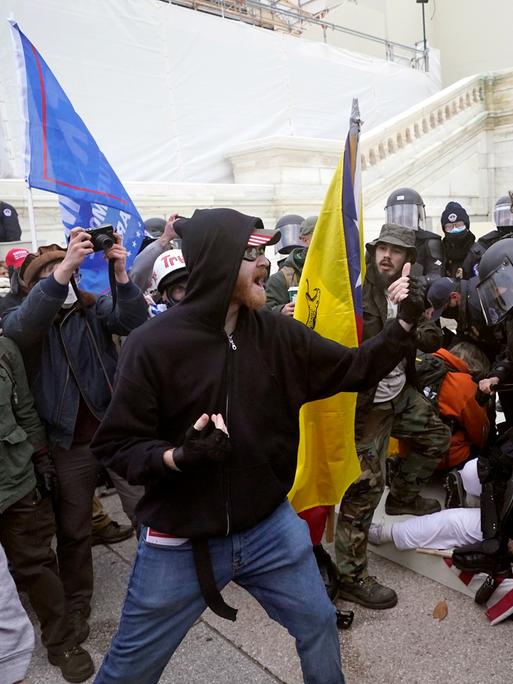 Tumultartige Auseinandersetzungen zwischen maskierten Trump-Anhängern und der Polizei vor dem Kapitol in den USA.