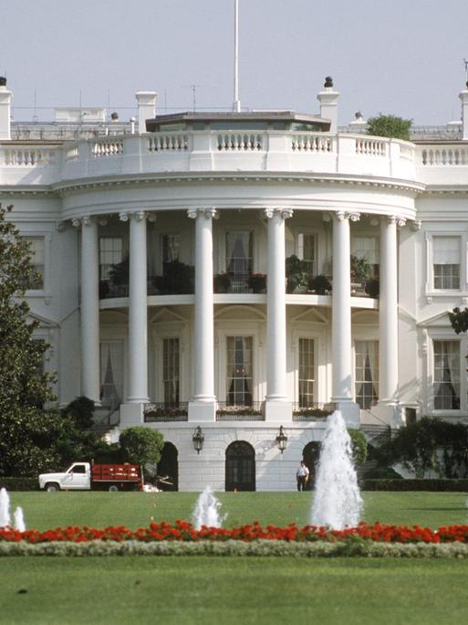 Blick über den Rasen und kleine Fontänen auf das Weiße Haus in Washington D.C., dem Amtssitz des amerikanischen Präsidenten
