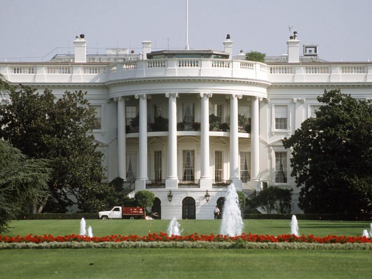 Blick über den Rasen und kleine Fontänen auf das Weiße Haus in Washington D.C., dem Amtssitz des amerikanischen Präsidenten