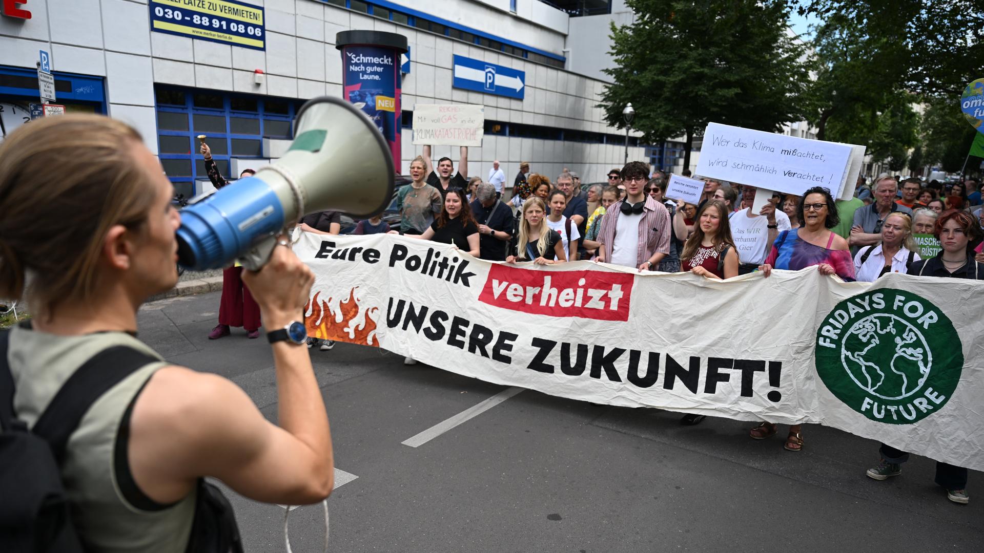 Demonstranten nehmen mit einem Plakat "Eure Politik verheizt unsere Zukunft!" in Berlin an einem Protest von Fridays for Future teil. Demonstranten nehmen mit einem Plakat "Eure Politik verheizt unsere Zukunft!" in Berlin an einem Protest von Fridays for Future teil.