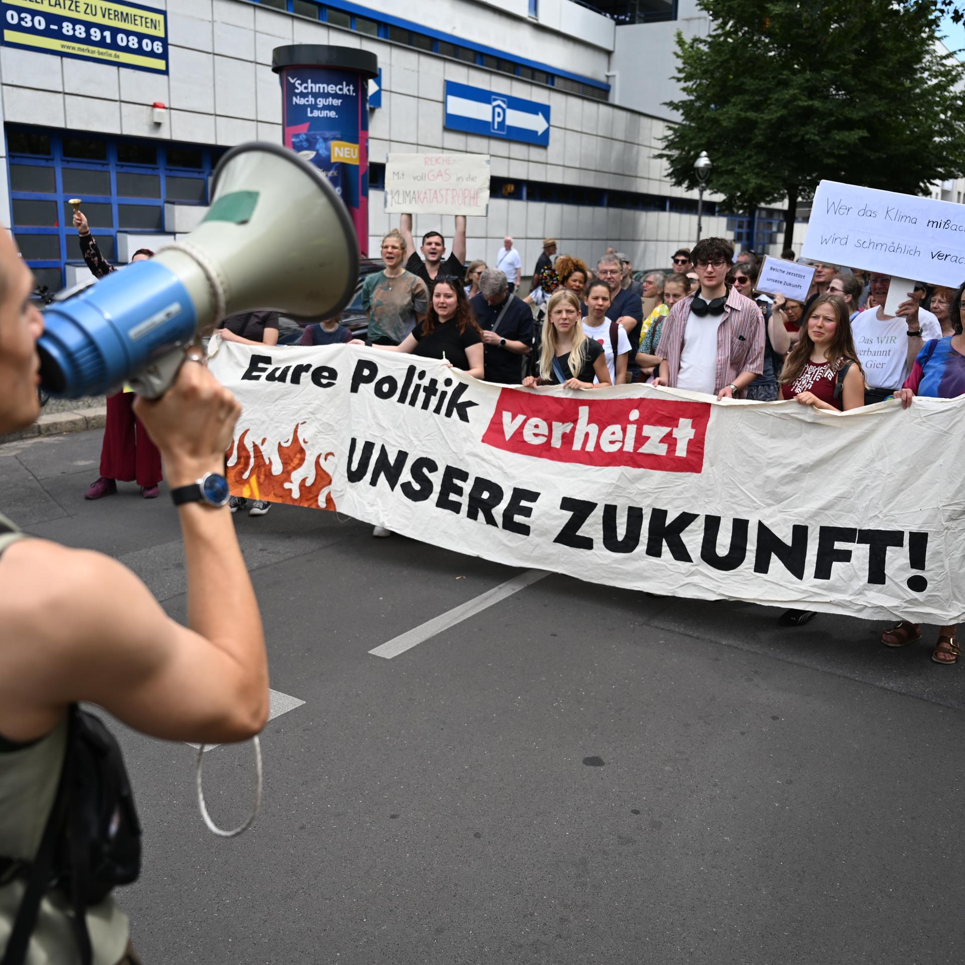 Demonstranten nehmen mit einem Plakat "Eure Politik verheizt unsere Zukunft!" in Berlin an einem Protest von Fridays for Future teil.