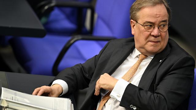 Armin Laschet (CDU) sitzt im Plenarsaal des Bundestag vor einem Aktenstapel.