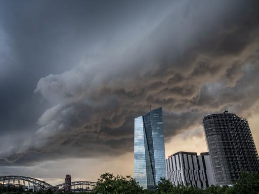Dunkle Gewitterwolken ziehen abends über die Zentrale der Europäischen Zentralbank (EZB) in Frankfurt hinweg.