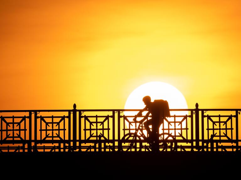 Der Fahrer eines Lieferdiensts fährt über die Theodor-Heuss-Brücke.