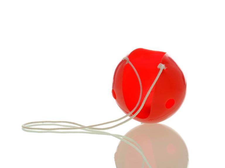 Eine rote Clownsnase an einem weißen Gummiband