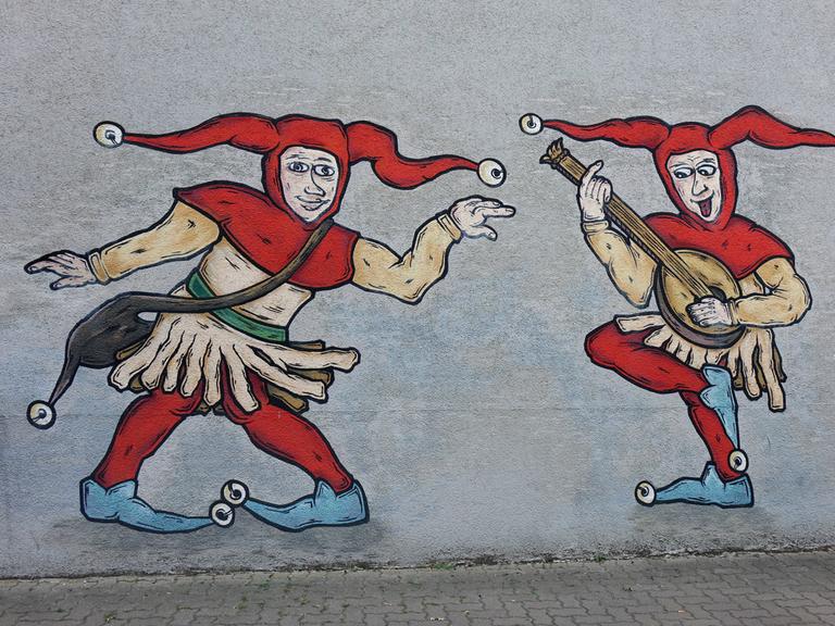 Zwei Hofnarren sind als Graffiti an einer Wand angebracht.  