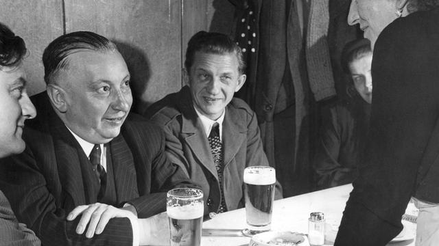 Ein Schwarz-Weiß-Foto zeigt den damaligen CSU-Vorsitzenden Josef Müller (2.v.li.) beim Bier trinken mit seinem jungen Mitarbeiter Franz Josef Strauß (1.v.li.).