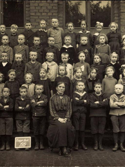 Historisches Foto einer gemischten Schulklasse aus dem Jahre 1919 mit Sepiafärbung.