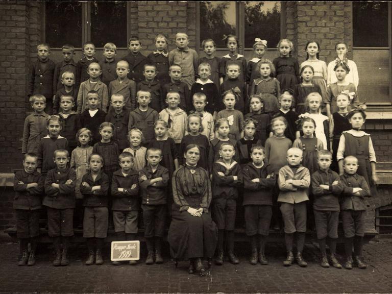Historisches Foto einer gemischten Schulklasse aus dem Jahre 1919 mit Sepiafärbung.