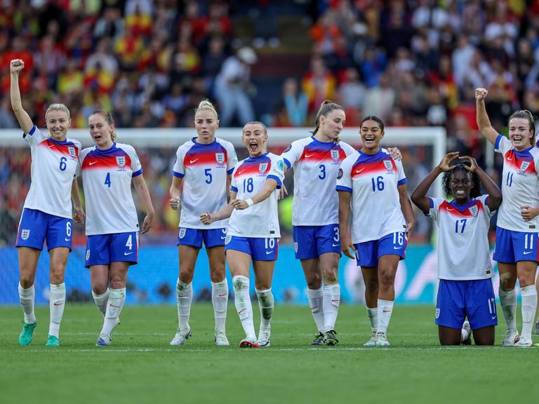 Englands Fußballerinnen in weißen Trikots und blauen Hosen feiern ihren EM-Finalsieg gegen Spanien.