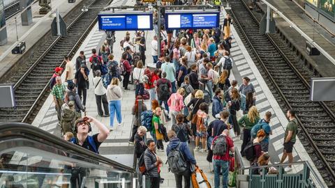Viele Passagiere an einem Bahngleis ohne Zug.